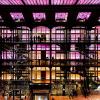 La vue interne d’un bâtiment avec 4 étages qui vont de l’orange au magenta. Le style est proche de l’époque victorienne