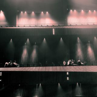 Photo des balcons d'une salle de concert moderne. La perspective donne l'impression que c'est une photo d'un paquebot avec quelques personne sur le pont