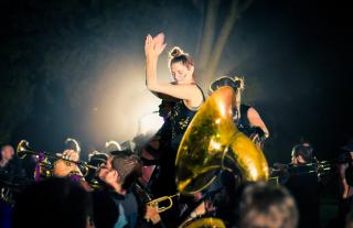 Femme illuminée clappant des mains derrière un cor