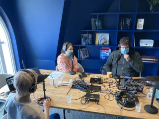 Enregistrement du premier épisode 3 Personne autour d'une table de réunion, avec deux interfaces audio raccordé à des micros via des cables, le tout branché à un ordinateur