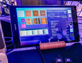 Tablet on the desk with big square buttons to turn on or off lights including the webcam light
