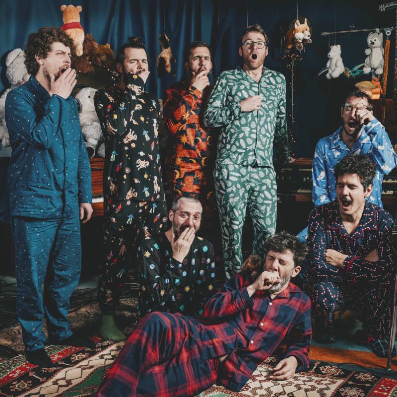 Le groupe en pyjama qui bâille, avec des peluches qui pendent partout autour d'eux