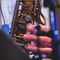 Saxophone closeup with finger playing it  