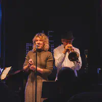 A signer with Erik Truffaz playing trumpet in the back. (name of the woman unknown, any information is welcome) 